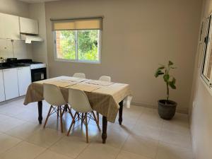 una cocina con una mesa con sillas y una planta en Departamento pie del cerro en Yerba Buena