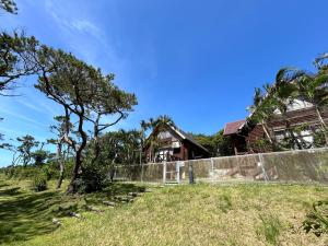 una casa en una colina con una valla en Tokashiki Guest House en Tokashiki