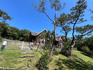 a house on a hill with a fence at Tokashiki Guest House in Tokashiki