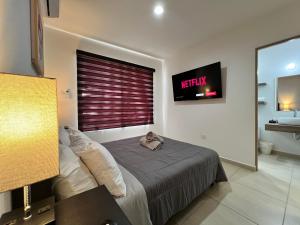 um quarto com uma cama e uma televisão na parede em New-Promo-Family-Pool-Gated-Sleeps 10-Near Beach em Mazatlán