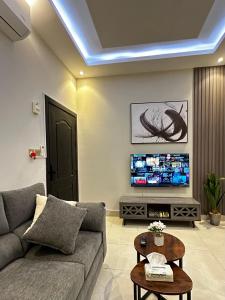 sala de estar con sofá y TV en هابي رومز en Al Khobar