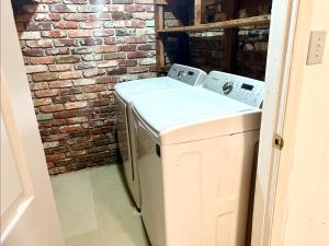 a washer and dryer in front of a brick wall at Queen Suite with Wifi with Hot Tub Room 5 in Atlanta