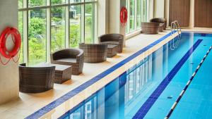 a pool in a hotel with wicker chairs and a swimming pool at LOTTE City Hotel Mapo in Seoul