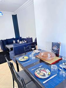 a dining room table with a blue table cloth and glasses at Residence Chay - Appartement de luxe in Ouarzazate