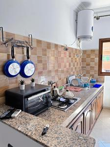 a kitchen with a stove and some pots and pans at Residence Chay - Appartement de luxe in Ouarzazate