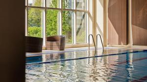 a swimming pool in a building with a large window at LOTTE City Hotel Mapo in Seoul