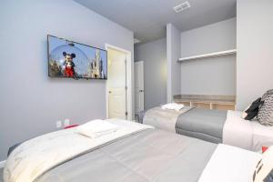 1 dormitorio con 2 camas y un cuadro en la pared en DLuxx Paradiso Brand New Top Elegance House 6151, en Orlando