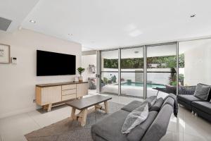 a living room with a couch and a tv at Amazing Water Views with Direct Beach Access in Marcoola