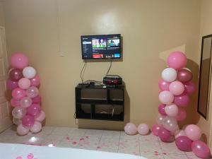 a room with pink balloons and a tv and a tv at Marshan villa in Montego Bay