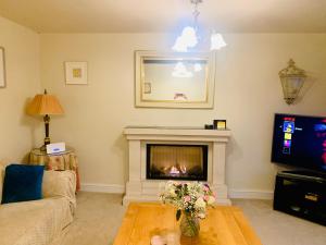 a living room with a fireplace and a tv at Tilly Cottage - overlooking Pendle Hill in Barrowford