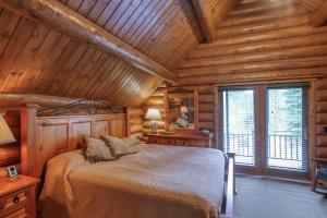 a bedroom with a bed in a log cabin at Bear Butte Gulch Lodge in Deadwood