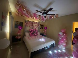 a room with a bed with balloons and a ceiling fan at Marshan villa in Montego Bay