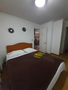 1 dormitorio con 1 cama grande y toallas amarillas. en Departamento Souza, en Santiago