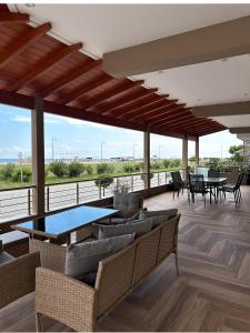a living room with couches and tables on a deck at SKYLINE Fine Living in Nei Poroi
