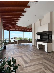 an empty living room with a fireplace and a table at SKYLINE Fine Living in Nei Poroi