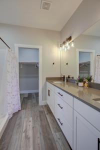 a white bathroom with a sink and a mirror at The Sand's Ours, Just Say When in Ocean Shores