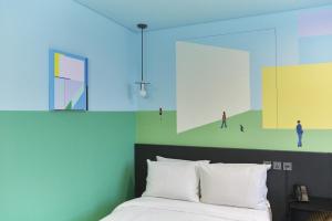 فندق كابتشينو في سول: غرفة نوم بسرير مع لوحة على الحائط