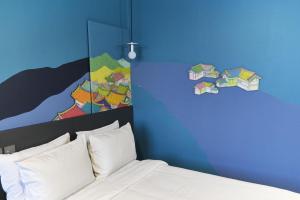 فندق كابتشينو في سول: غرفة نوم بسرير ودهان على الحائط