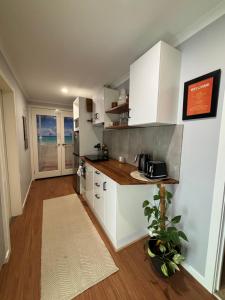a kitchen with white cabinets and a wooden floor at Kima Quarters in Swan Hill
