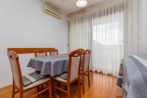 a dining room with a table and chairs and a window at Apartments with a parking space Zagreb - 22137 in Zagreb
