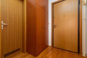 pusty korytarz z dwoma drewnianymi drzwiami i drewnianą podłogą w obiekcie Apartments with a parking space Zagreb - 22137 w Zagrzebiu