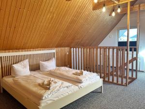 a large bed in a room with a wooden ceiling at ETW Hausberg 45 - Fr Schwenn in Sassnitz