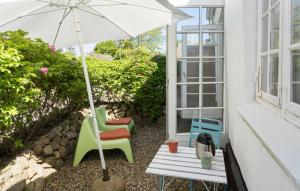 a patio with a table and chairs and an umbrella at 1 Bedroom Pet Friendly Home In Haderslev in Haderslev