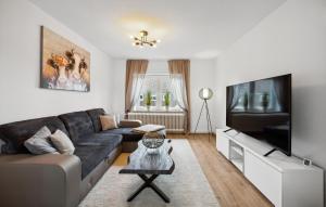 a living room with a couch and a flat screen tv at Küstenkind in Wilhelmshaven