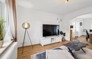 a white living room with a flat screen tv at Küstenkind in Wilhelmshaven +12 photos