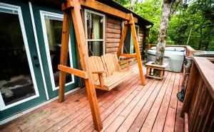 eine Holzterrasse mit einem Stuhl auf einer Hütte in der Unterkunft Starlight Haven Hot Springs in Hot Springs