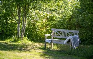 a wooden bench with a blanket on it in a park at Stunning Home In Farsø With Sauna in Farsø