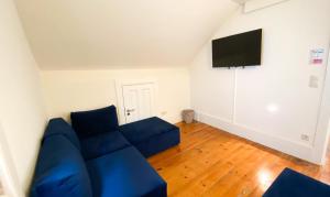 un soggiorno con divano blu e TV a schermo piatto di Nº 91 - Almirante Guest House a Porto