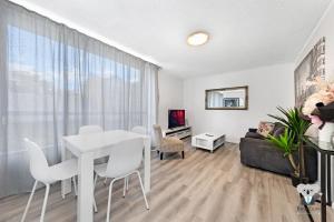 un soggiorno con tavolo e sedie bianchi di KozyGuru Redfern Charming 1 Bed Parking NRE012 a Sydney