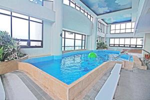 馬尼拉的住宿－BSA雙子塔酒店，一座大型游泳池,位于一座带窗户的建筑内