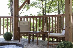 una terraza de madera con mesa y 2 sillas en Bois Des Nauzes, en Seyches