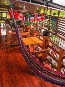 a hammock on a boat with a table and benches at Hostal Raíces de mi Pueblo in Suchitoto
