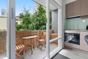 cocina con balcón con mesa y sillas en Contemporary 1-Bed Apartment Moments from MCG en Melbourne