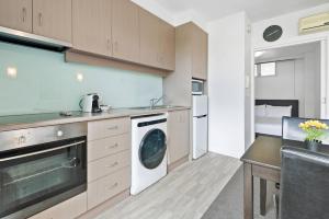 y cocina con lavadora y secadora. en Contemporary 1-Bed Apartment Moments from MCG en Melbourne