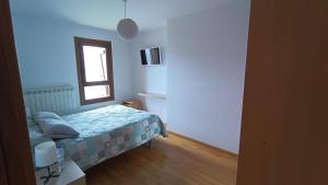 una piccola camera da letto con un letto e una finestra di Un balcon al paraiso a Cerler