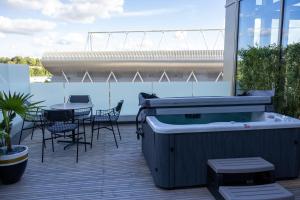 una vasca idromassaggio su una terrazza con tavolo e sedie di voco Leicester, an IHG Hotel a Leicester