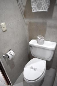 a bathroom with a white toilet with a bow on it at Hotel Plaza Almendros in Isla Mujeres