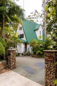 a white house with a green roof and a driveway at Hope Cottage - Tamborine Mountain in Mount Tamborine