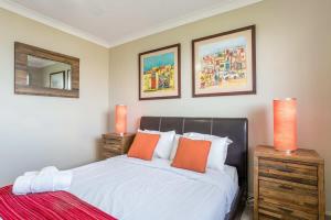 a bedroom with a bed with orange pillows at Inner City Pad - Indooroopilly in Brisbane