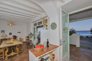 a kitchen and dining room with a view of the ocean at Villa Mareblu Luxury Holiday Apartment direttamente sul mare in Stromboli