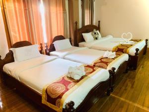 um grupo de três camas num quarto em Happy Riverview Hotel em Vang Vieng