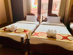 duas camas sentadas uma ao lado da outra num quarto em Happy Riverview Hotel em Vang Vieng