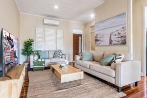 - un salon avec un canapé et une table dans l'établissement Elegant 4-Bedroom Residence with Entertaining Area, à Brisbane