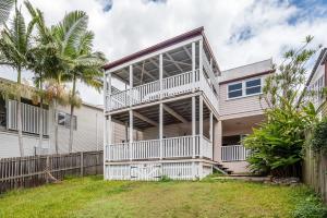 Cette maison blanche dispose d'un balcon et d'une clôture. dans l'établissement Elegant 4-Bedroom Residence with Entertaining Area, à Brisbane
