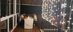 un grupo de personas sentadas en una mesa con luces en Mayflower Holiday Villa, en Meppādi