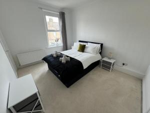 a white bedroom with a bed and a table at Cumberland House-2 Bed House in Workington